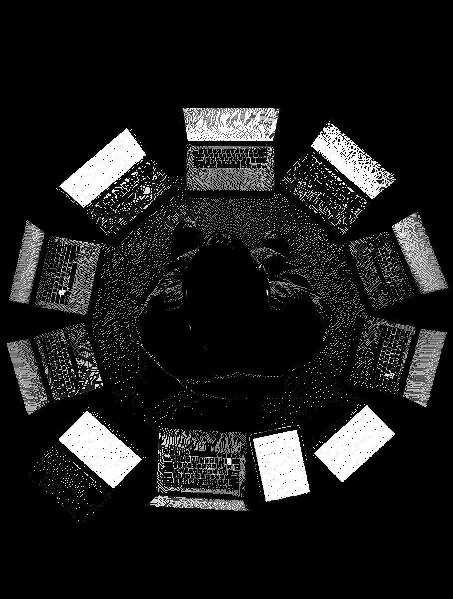 One person at a desk, ringed by a dozen open laptops.